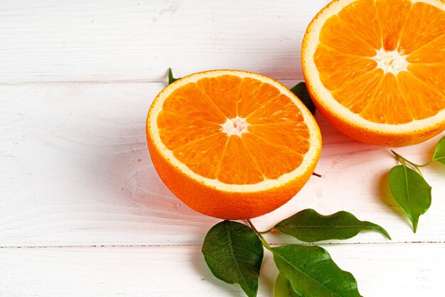 Cut oranges on wooden board on table