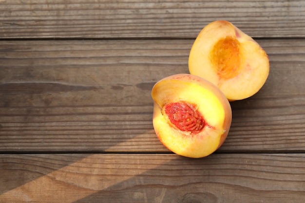 cut peaches on the wooden background with copy space