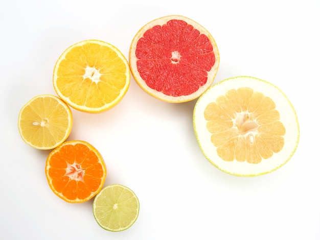 Cut pieces of different citrus fruits on white background