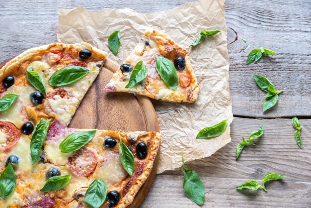 Tagliare la pizza sulla tavola di legno