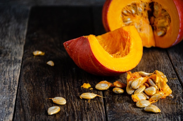 Photo cut the pumpkin and its seeds on wooden boards.