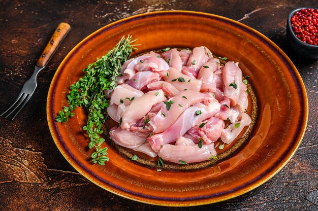 Cut Raw Chicken breast fillet on a plate.  Dark background. Top view.