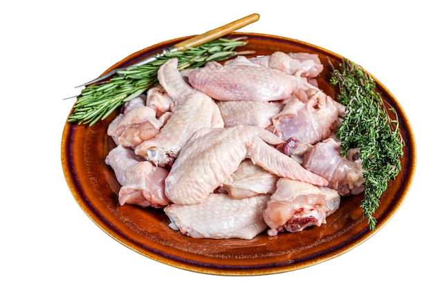 Cut Raw chicken wings in a rustic plate with thyme and rosemary Isolated on white background