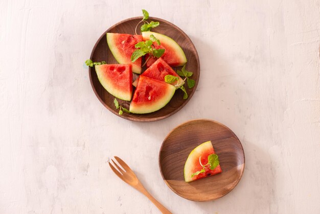 Cut slices of ripe juicy watermelon on wood plate