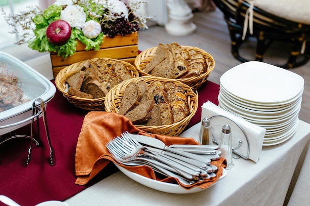 Cut slices of whole grain rye bread laid out on the plates Catering covered table