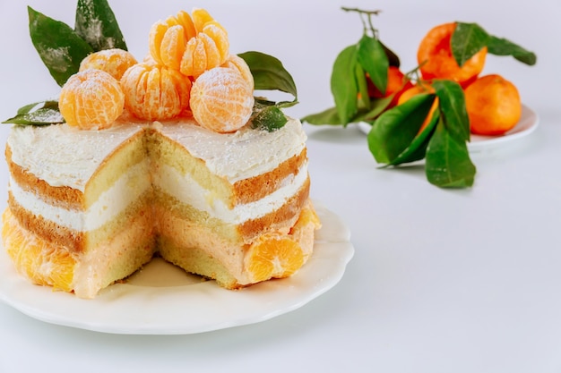 Cut sponge cake with mandarin cream and fresh clementines
