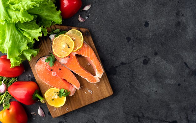 Tagliare il salmone della bistecca sul banner della tavola di legno