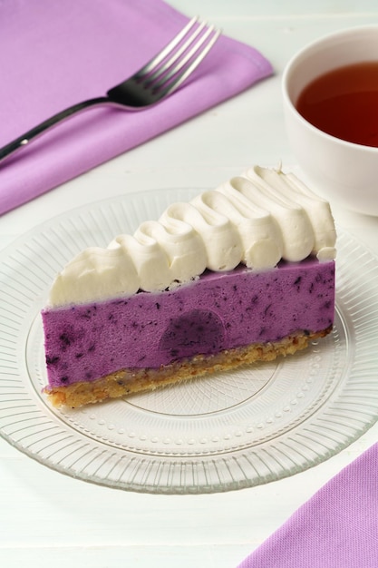 Cut tasty blueberry cake on white table