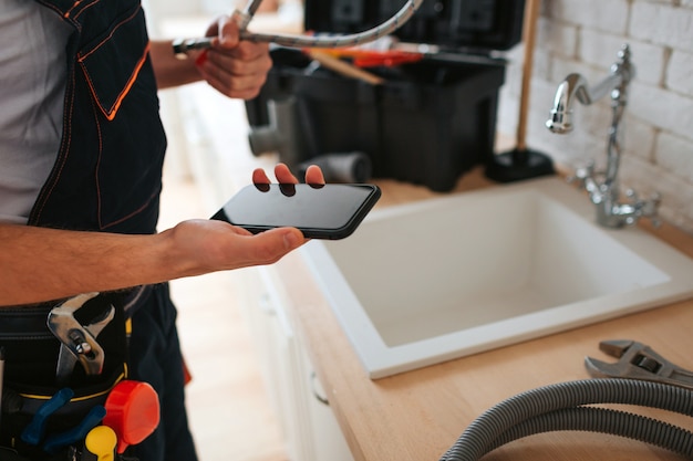 Cut view of man standing in kitchen at sink