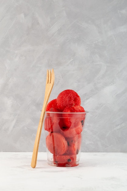 Cut Watermelon in plastic cup on grey background Fresh red watermelon pulp Selective focus