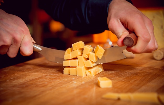 Tagliare con un coltello un pezzo di formaggio