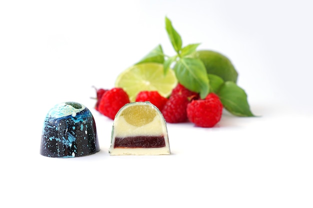 Cutaway chocolate candy raspberry lime and basil on a white background