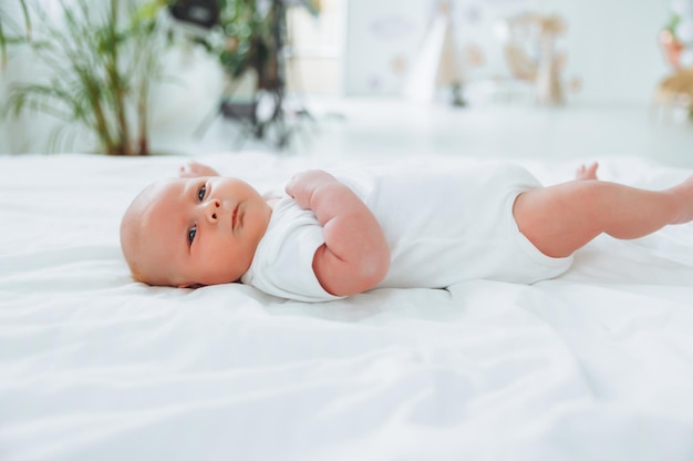 Carino 2 mesi bambino sdraiato sul letto biancheria da letto naturale pelle delicata del bambino