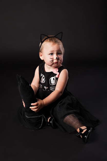 写真 黒の背景に猫の衣装でかわいいアビーの女の子