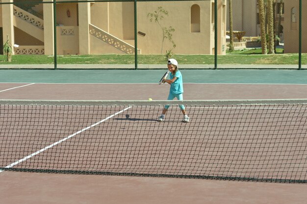 Photo cute active little girl playing tennis  outdoor