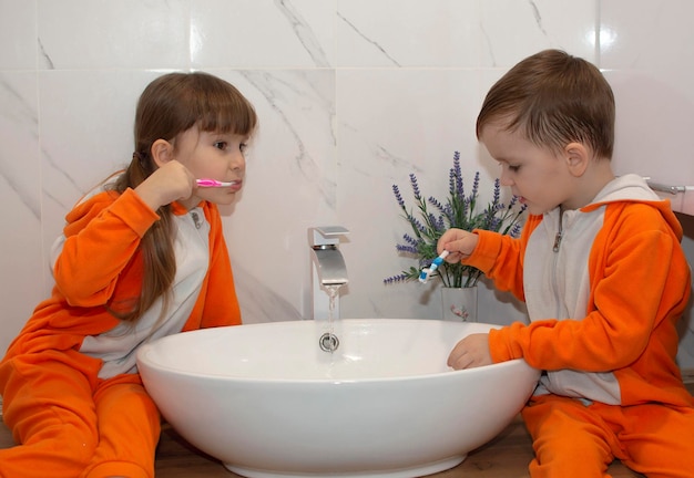 Cute adorable baby girl holding toothbrush and brushing her teeth in bathroom. Child learns to stay healthy. Morning healthy hygiene for children.