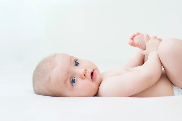 Cute adorable baby girl lying on the bed