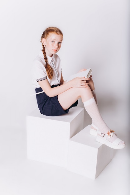 Cute adorable caucasian blondie girl in school uniform on white background