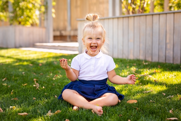 Cute adorable Caucasian toddler baby girl sitting and eating