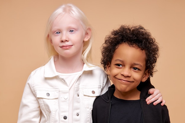 Bambini diversi adorabili svegli che sorridono insieme isolati