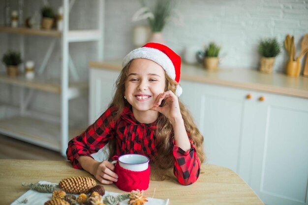 Photo cute adorable smiling girl in santa claus hat at home