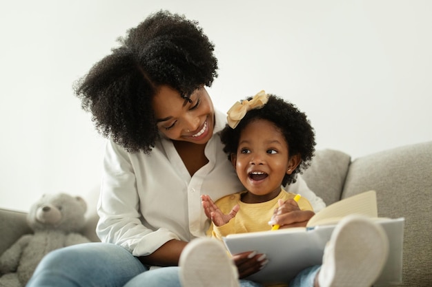 Cute african american baby girl enjoying development activities with mom