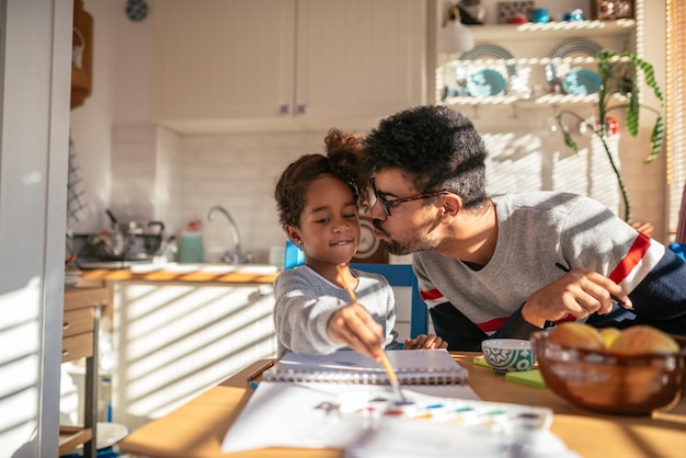 Cute african american girl painting at home