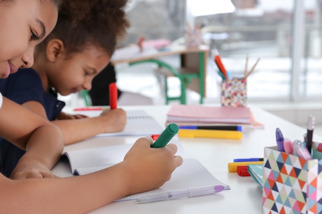 Photo cute african-american girls drawing at lesson