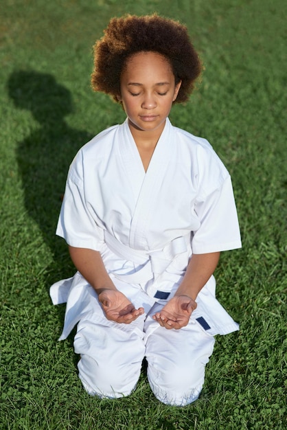 Photo cute afro american girl sitting on grass and meditating