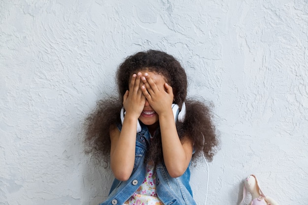 Photo cute afro girl at home listening to  music