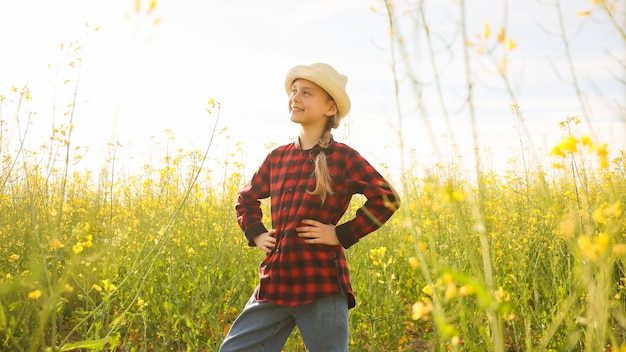 写真 麗で笑顔の小さな女の子農家の娘花がく畑でひげの上に手を置いて