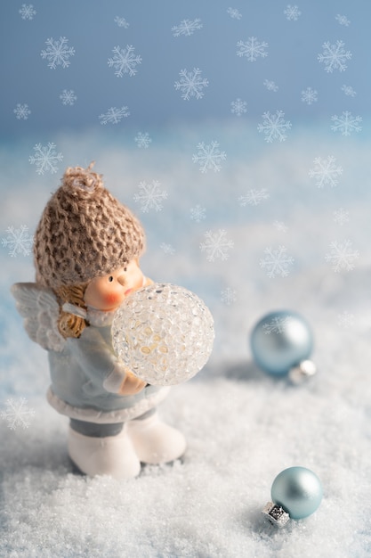 かわいい天使、雪の中で青いクリスマスの飾り、クリスマスカード。高品質の写真