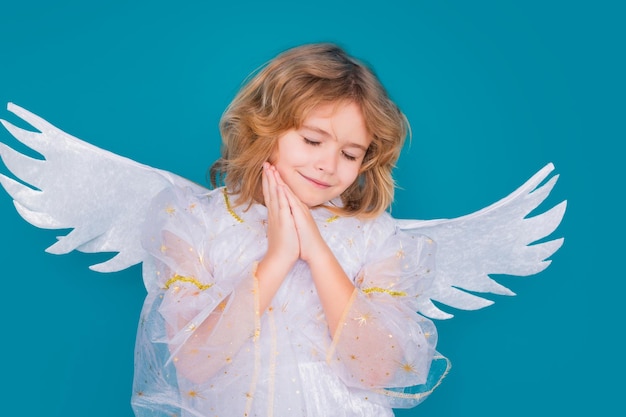 Cute angel kid studio portrait blonde curly little angel child with angels wings isolated background