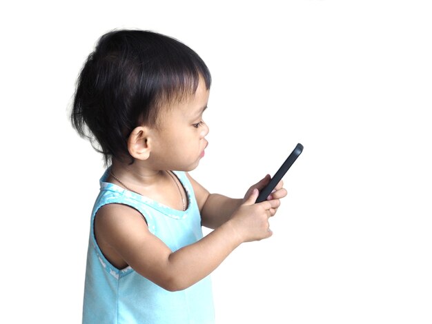 Cute Asian baby girl looking video or playing media at smart phone, isolated on white background. Child development concept.