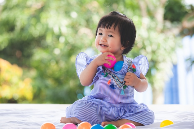 幸せで彼女のおもちゃで遊んでいるかわいいアジアの女の子