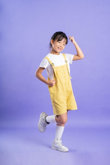 Cute asian baby girl posing on purple background