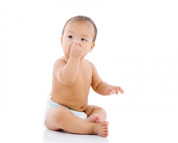 Cute asian baby sitting on the floor isolated on white 