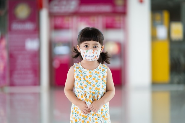 コロナウイルスを保護するためのマスクを身に着けているかわいいアジアの赤ちゃん。
