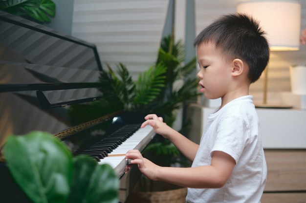 Cute Asian boy playing the piano