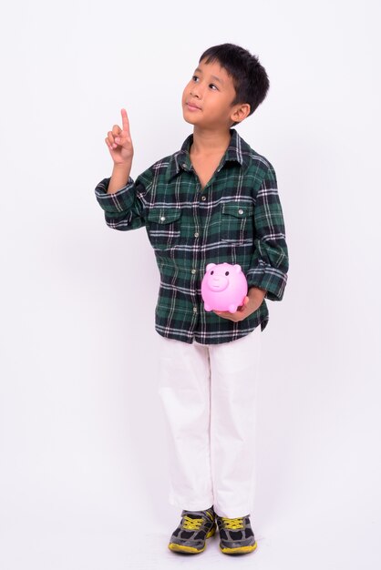  cute Asian boy wearing green checkered shirt against white wall