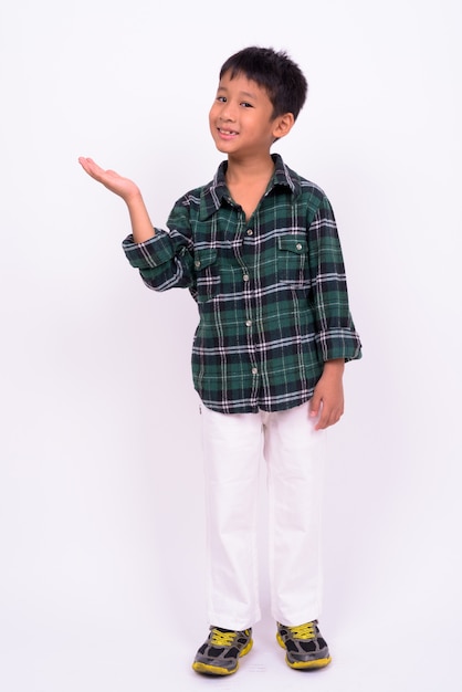  cute Asian boy wearing green checkered shirt against white wall