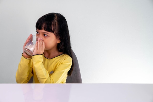 彼女の食事のためにミルクを飲むかわいいアジアの子供の女の子