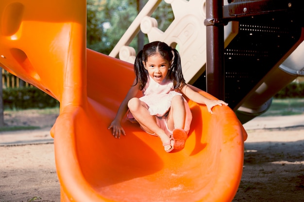여름 시간에 놀이터에서 슬라이더를 재생하는 재미 귀여운 아시아 아이 소녀