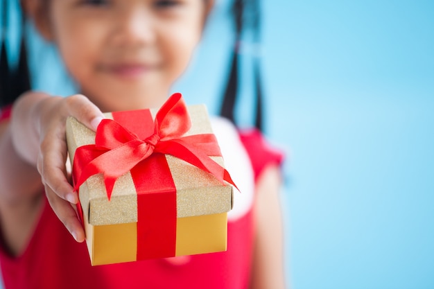 Cute asian child girl holding beautiful gift in hand on Christmas celebration