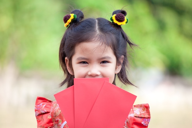 빨간 봉투를 들고 귀여운 아시아 아이 소녀