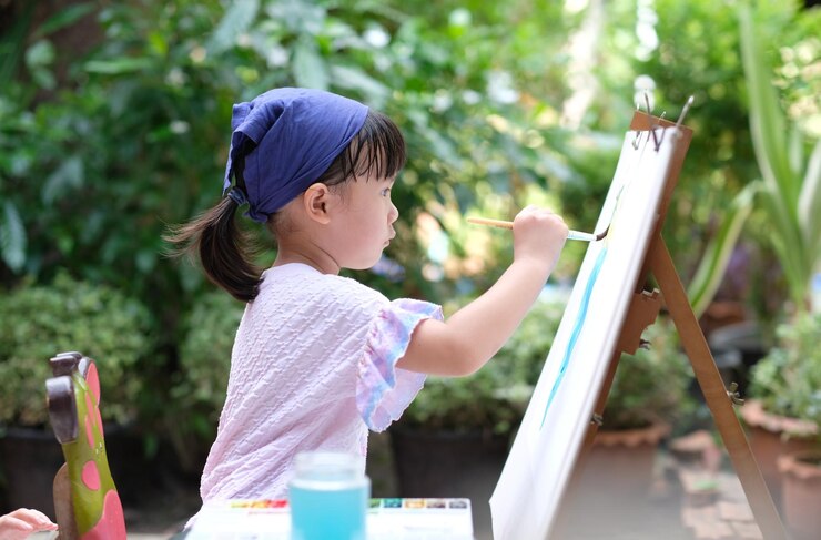Photo 可愛いアジアの子供の女の子がペイントブレスを持って紙に絵を描いています 選択的な焦点