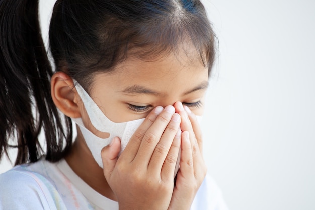 Cute asian child girl wearing protection mask to against air smog pollution