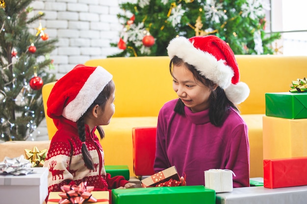 Симпатичные азиатские девочки с подарками и украшениями для празднования Рождества
