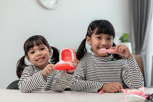 Cute Asian child playing with doctor dentist toy set child shows how to clean and care for teeth Dentistry and medicine