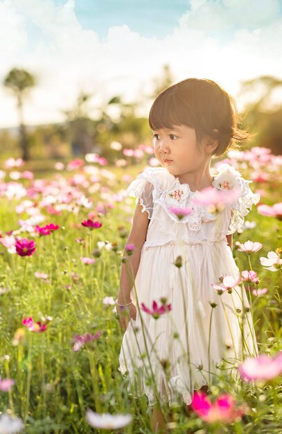 Cute asian children girl in nature flowers field